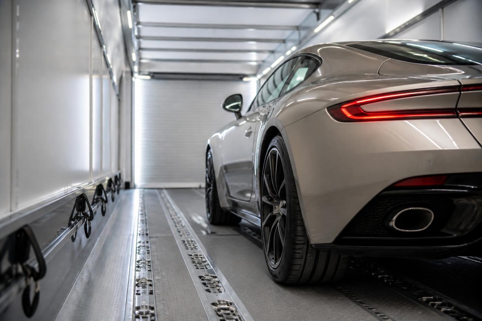 Luxury car inside a clean enclosed transport trailer.